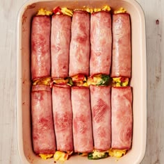 ham wrapped in bacon and vegetables on a baking sheet