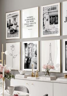 a dining room with pictures on the wall and flowers in vases next to it