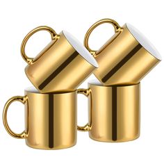 two gold coffee mugs with handles on each one