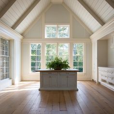 a kitchen with an island in the middle and lots of windows on both sides,