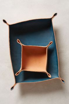 a blue and brown square shaped dish on a white surface