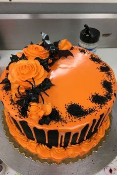 a cake with orange frosting and black decorations