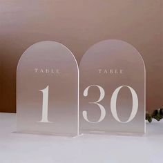 two clear acrylic table numbers are on display