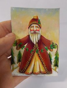 a hand holding a small card with a santa clause on it