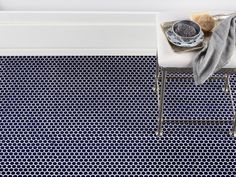 a bath room with a white tub and a blue flooring pattern on the floor