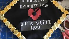 a decorated graduation cap that says despite everything it's still you with flowers around the edges