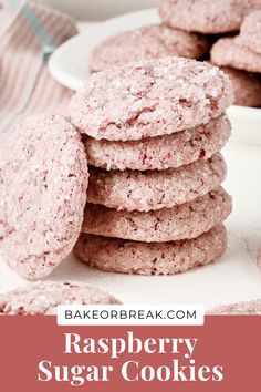 raspberry sugar cookies stacked on top of each other in front of a white plate