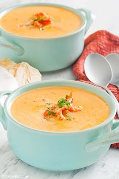 two blue bowls filled with soup on top of a table