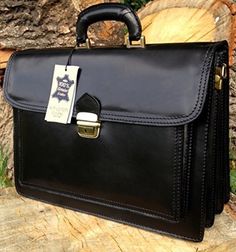 a black leather briefcase sitting on top of a tree stump