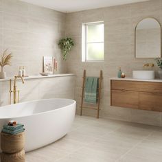 a white bath tub sitting in a bathroom next to a sink and mirror on a wall