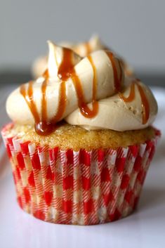 a cupcake topped with whipped cream and caramel drizzle