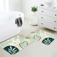 two bath mats in front of a tub with plants on the floor next to it