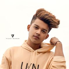 a young man wearing a tan hoodie with the word un written on it