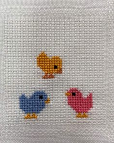 three little birds cross stitched together on a white pillow