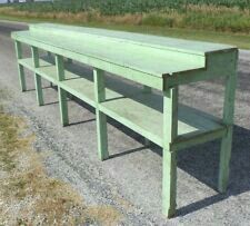 a green bench sitting on the side of a road