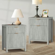 two nightstands with lamps on top of them in a room next to each other