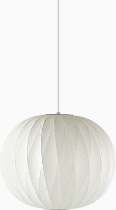 a white light hanging from a ceiling fixture with an intricate pattern on it's surface