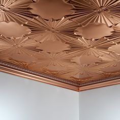 the ceiling is decorated with intricately designed copper tints and decorative moldings in this room