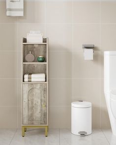 a white toilet sitting next to a wooden cabinet