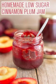 a jar filled with jam sitting on top of a wooden table next to sliced apples