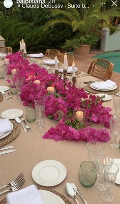 the table is set with flowers and candles