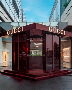 the entrance to a gucci store in an urban area with red lights on it