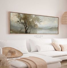 a living room with white furniture and a painting on the wall above it's couch