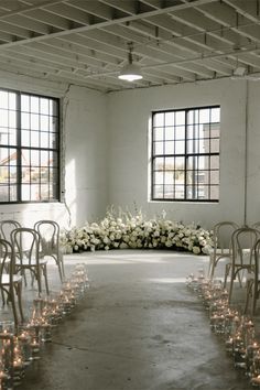 an empty room with rows of chairs and candles