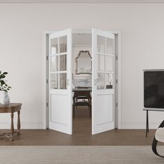 an open door leading to a living room with a television and table in the corner