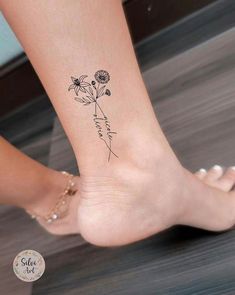 a woman's foot with a flower tattoo on the side of her leg,