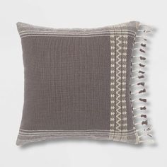 two gray and white pillows with tassels