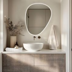 a bathroom with a sink, mirror and towel on the counter top in front of it