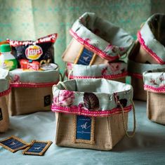 several bags are sitting on a table with some snacks in them and one bag is empty