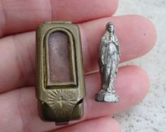 a small silver object with a statue in the background