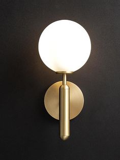 a light that is on the side of a wall mounted lamp with a black background