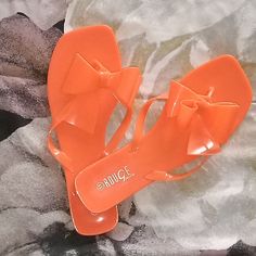 Never Worn. Orange Jelly Thong Sandals With A Bow. Very Cute For Spring And Summer! Orange Summer Flip Flops For Vacation, Orange Flat Flip Flops For Summer, Summer Orange Flip Flops For Beach, Summer Orange Flat Flip Flops, Orange Summer Flip Flops, Orange Synthetic Flip Flops For Summer, Orange Flat Flip Flops For Vacation, Summer Jelly Sandals For Beach Season Parties, Orange Open Toe Flip Flops For Summer