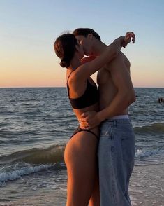 a man and woman kissing on the beach