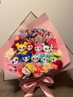 a bunch of stuffed animals sitting in a bouquet on top of a wooden floor next to a wall