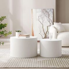 two white tables sitting on top of a rug