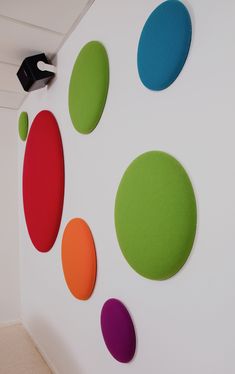 the wall is decorated with different colored circles and black object on it's side