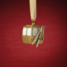 a gold ornament hanging from a red wall with scissors and other items on it