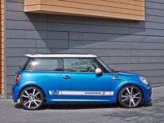 a small blue car parked in front of a building