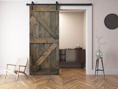 an open barn door in a living room with a chair and clock on the wall