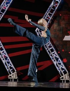 a man is performing on stage with his leg in the air