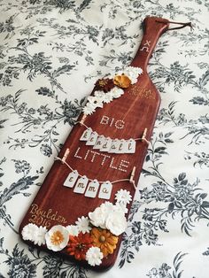 a wooden board decorated with flowers and words