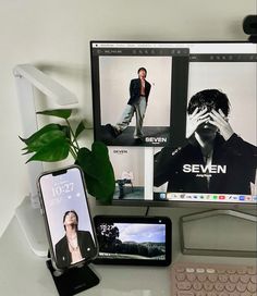 two cell phones are sitting on a desk next to a computer monitor and keyboard,