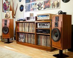 an entertainment center with speakers, cd players and other musical equipment on display in a living room