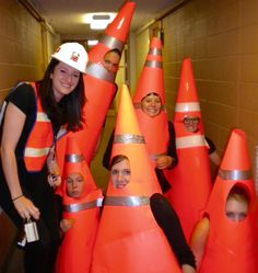 a group of people wearing orange cones with faces on them in an office building hallway