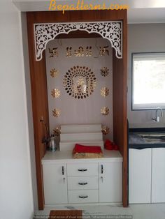 a kitchen area with white cabinets and gold decorations on the wall, along with a wooden table