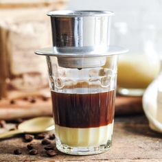 a shot glass filled with liquid and coffee beans